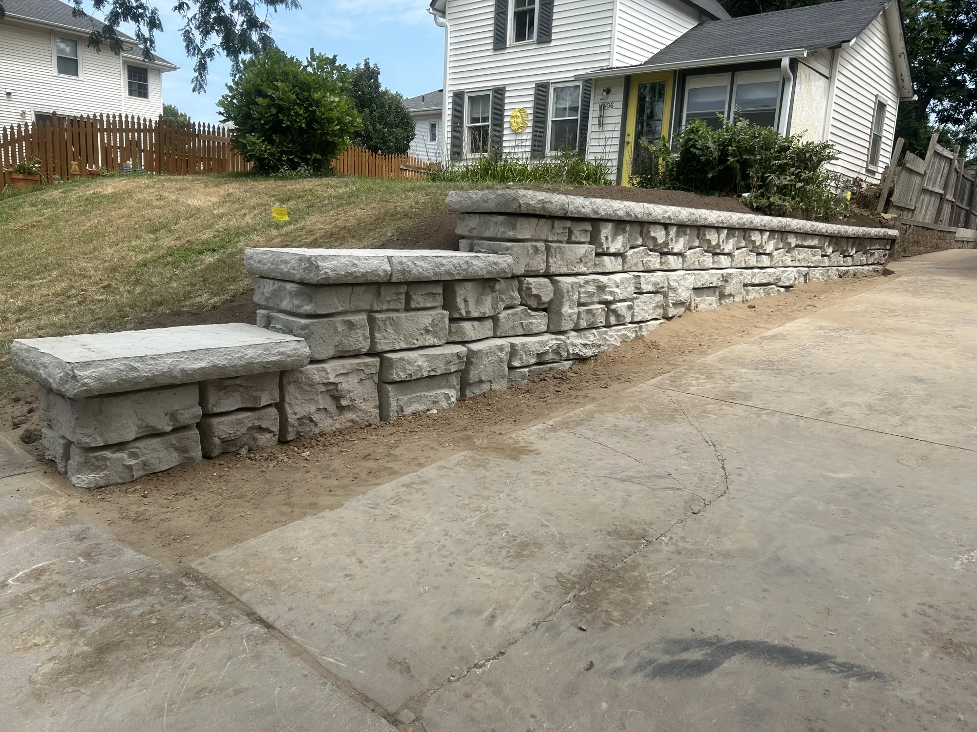 Stone retaining wall alongside a residential driveway